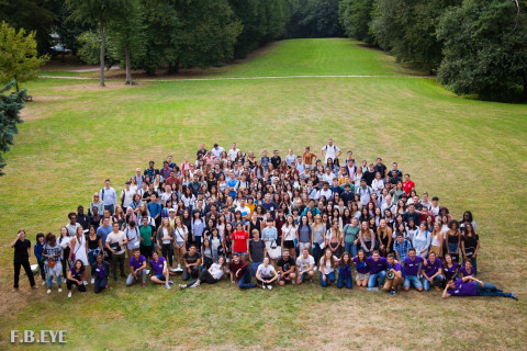 Étudiants des unions étudiantes de NEOMA Rouen posant ensemble sur une pelouse du campus